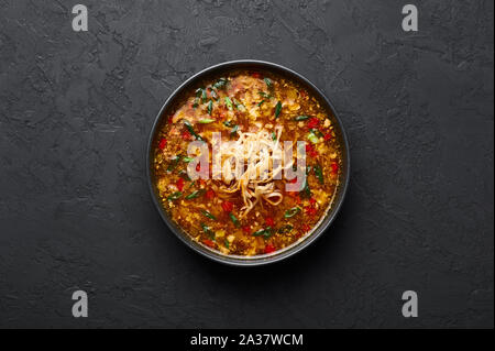 Veg Manchow soupe dans un bol noir dark slate à fond. Manchow soupe végétarienne est l'indo-chinoise plat avec les poivrons, le chou, carotte, nood Banque D'Images