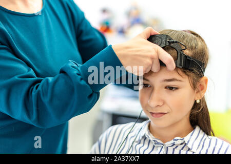 Jeune adolescente et thérapeute pour enfants au cours de l'EEG neurofeedback session. Concept L'électroencéphalographie. Banque D'Images