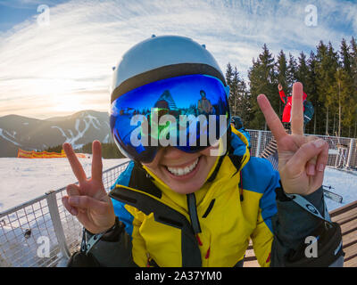 Les amis s'amusant de prendre photo sur le haut de la colline de neige. reflet dans les lunettes. Ski et snowboard Banque D'Images