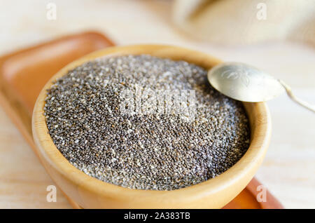 Close up de chia seeds, Salvia hispanica, dans bol en bois sur une table rustique. Ce superfood est un riche en acides gras oméga-3, essentiels à une bonne santé Banque D'Images