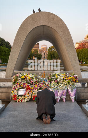 HIROSHIMA, JAPON - 23 NOVEMBRE 2007 : Le vieil homme priant devant le cénotaphe commémoratif pour les victimes de la bombe. Colombes de paix sont assis sur le Banque D'Images