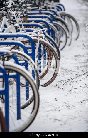 Les vélos en stationnement sur une rue enneigée à Amsterdam, Pays-Bas Banque D'Images