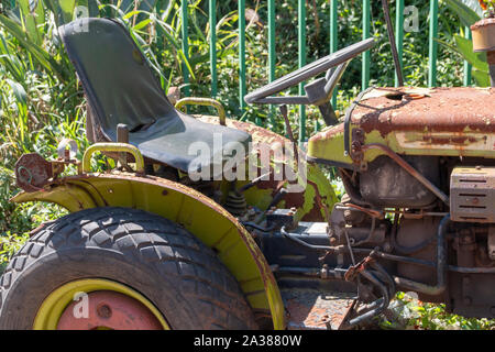 Une vue en gros plan d'un petit vieux tracteur rouillé assis sur le soleil chaud Banque D'Images