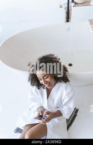 Woman having fun texting avec son amie Banque D'Images