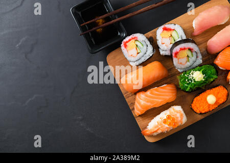 Close up of sushi sashimi set avec des baguettes sur la plaque de bois, de la nourriture japonaise populaire Banque D'Images