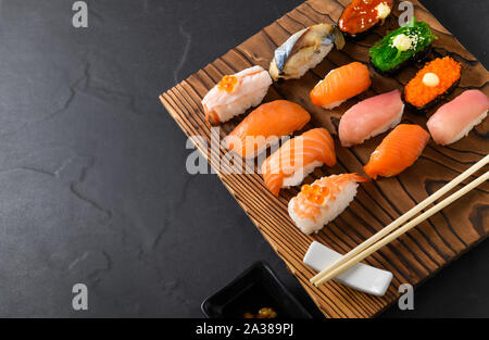 Close up of sushi sashimi set avec des baguettes sur la plaque de bois, de la nourriture japonaise Banque D'Images