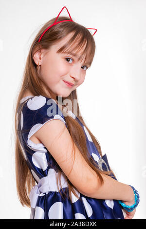 Portrait d'une petite fille joyeuse avec des oreilles de chat et dans une robe à pois Banque D'Images