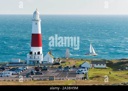 Portland Bill, Dorset, UK. 6e octobre 2019. Météo britannique. Un yacht à voile luttes passé Portland Bill lighthouse à travers les eaux agitées de la course de Portland pour un jour de soleil et de fortes rafales. Le phare de Portland Bill est actuellement en cours de modernisation par Trinity House à l'ancienne optique tournante d'être remplacé par un nouveau voyant. Les travaux ont commencé le 1er octobre doit s'achever le 27 février 2020. Crédit photo : Graham Hunt/Alamy Live News Banque D'Images