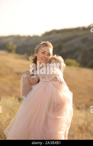 Une petite fille est au soleil et s'endormir sur l'épaule de sa mère. Banque D'Images