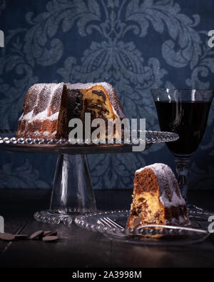 Gâteau marbré Bunt, Vin rouge et bleu foncé fond damassé Banque D'Images