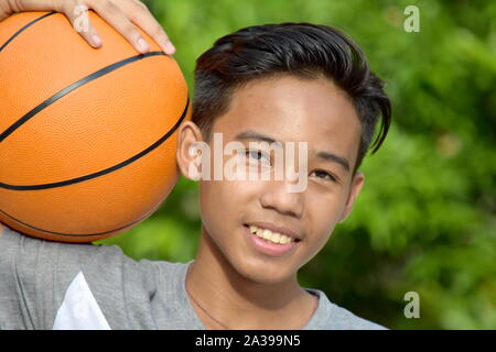 Jeune joueur de basket-ball masculin Basket-ball and Smiling Banque D'Images