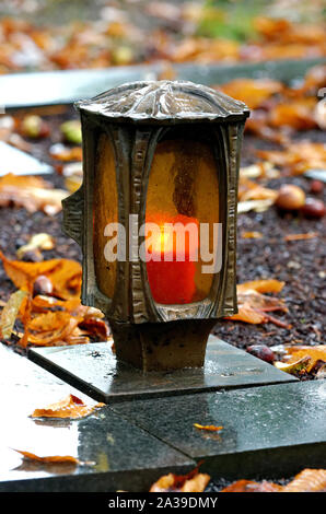 Lanterne tombe dans un cimetière sur un soir d'automne pluvieux Banque D'Images