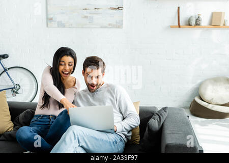 Choqué african american woman et bel homme looking at laptop Banque D'Images