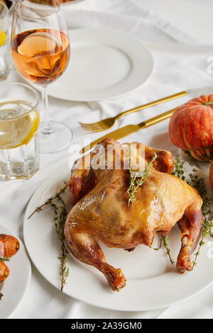 La Turquie grillés près de verres de vin blanc et de l'eau citronnée sur nappe blanche Banque D'Images