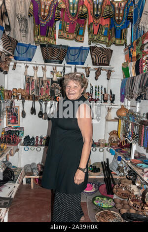 Femme souriante dans un petit magasin à la Maasai Market, central Arusha, Tanzanie Banque D'Images