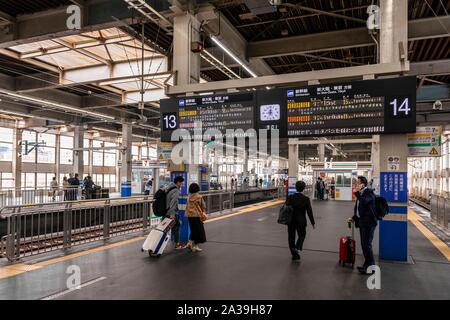 Les passagers de la plate-forme, l'affichage de l'information japonais à grande vitesse, la gare Shinkansen, Hiroshima, Japon Banque D'Images