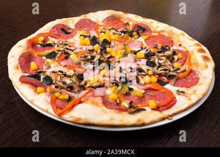 Pizza au pepperoni et champignons, le jambon et le poivron. Close-up. Banque D'Images