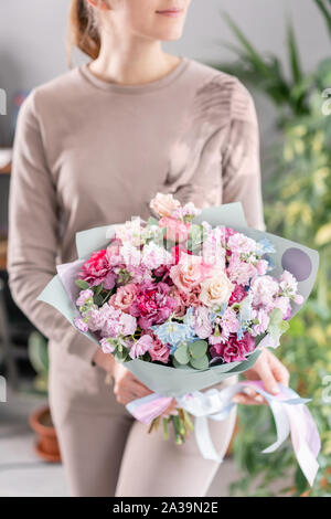 Couleur rose et violet. Beau bouquet de fleurs dans les mains de womans. le travail de la fleuriste à un magasin de fleur. Fleurs fraîches coupées. Banque D'Images