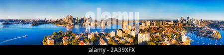 Large panorama de l'élevé la ville de Sydney CBD sur les rives du port de Sydney derrière Kirribilli banlieue résidentielle sur la Basse-Côte-Nord. Les eaux d'un bleu vif Banque D'Images