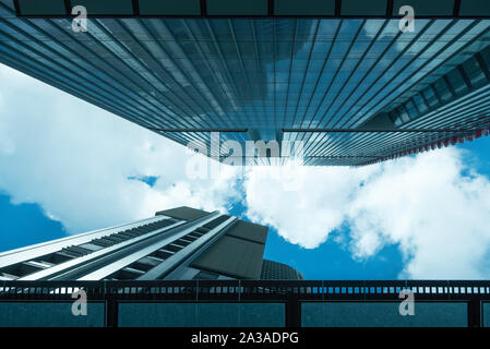 Regardant vers le ciel bleu et les nuages blancs dans un espace étroit entre l'augmentation des tours de bureaux en verre à Sydney, Australie Banque D'Images