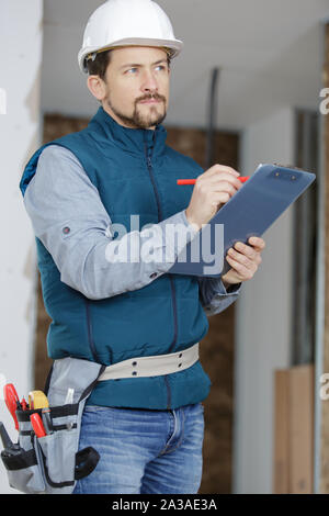 Construction builder sur chantier et presse-papiers mug Banque D'Images