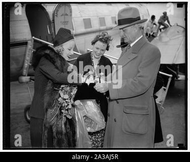 L'aide des sénateurs. Washington, D.C., le 15 mai. Le sénateur William Gibbs McAdoo, de Californie, vient à l'aide de Mlle Marion Weldon, Paramount starlette, comme elle le cherche pour sa beauté sida avant la foule de vœux à son arrivée à l'aéroport de Washington aujourd'hui. Mlle Jean O'Connell, fille d'Ambrose O'Connell, adjoint exécutif du ministre des Postes, est représentée dans le centre. Mme Weldon est ici pour participer à la Semaine nationale de la poste aérienne en tant que représentant d'Hollywood, et d'honneur pour lequel elle a été choisi par les 22 pilotes et cascadeurs qui font leur apparition dans avec elle à la prochaine plus haute Banque D'Images