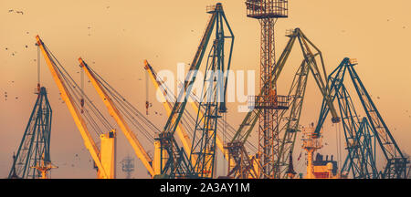 Coucher de soleil sur des grues industrielles à port de mer commercial de la ville de Varna, Bulgarie libre Banque D'Images