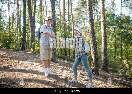 Couple d'adultes portant des sacs à dos randonnée en forêt Banque D'Images