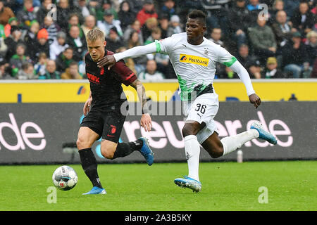 (191007) -- MONCHENGLADBACH, le 7 octobre 2019 (Xinhua) -- La Grosse Caye Breel (R) de Monchengladbach rivalise avec Philipp Max d'Augsbourg au cours de la Bundesliga match de foot entre Borussia Mönchengladbach et FC Augsburg à Mönchengladbach, Allemagne, le 6 octobre 2019. (Photo par Ulrich Hufnagel/Xinhua) Banque D'Images