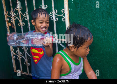 Un enfant joue avec l'eau pendant le festival de Higantes à Angono Philippines Banque D'Images