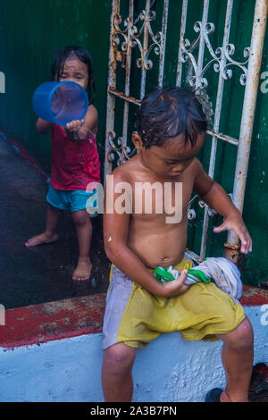 Un enfant joue avec l'eau pendant le festival de Higantes à Angono Philippines Banque D'Images