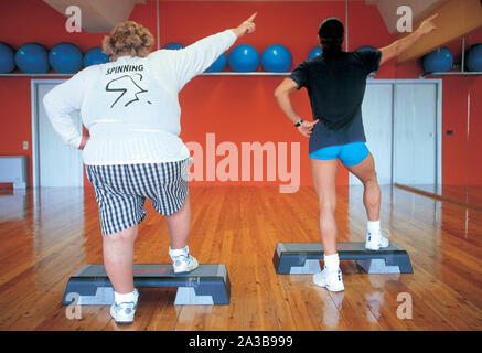 Grosse femme avec formateur, step aerobic Banque D'Images