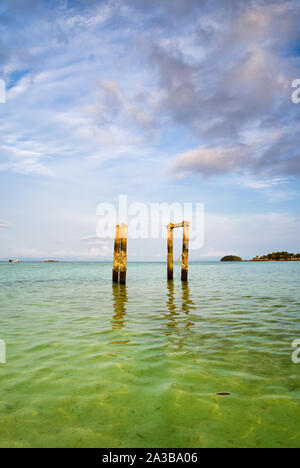 Piliers en béton d'une ancienne jetée abandonnée sur la plage de l'eau turquoise de l'île de Thaïlande Banque D'Images