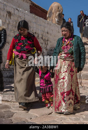 Les femmes tibétaines en costume traditionnel avec un enfant de faire le pèlerinage pour le Palais du Potala à Lhassa, au Tibet. Banque D'Images