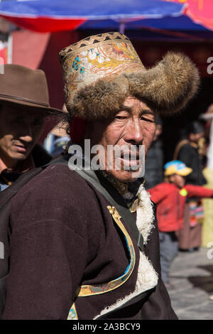 Un pèlerin bouddhiste tibétain de la région de Kham, Tibet circumambulates autour du Temple de Jokhang à Lhassa, Tibet, le port d'un fil d'or hat. Banque D'Images