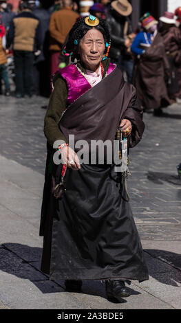 Un Khamba femme de la tibétaine du Kham, région est du Tibet avec ses cheveux en petites tresses traditionnelles et une coiffe de turquoise et or. Banque D'Images