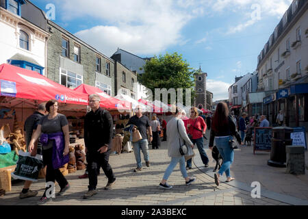 Gens touristes visiteurs à l'extérieur jeudi marché étals dans l'été Market Square Keswick Cumbria Angleterre Royaume-Uni Grande-Bretagne Banque D'Images