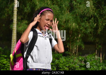 L'élève fille sous l'effort de porter l'uniforme scolaire Banque D'Images