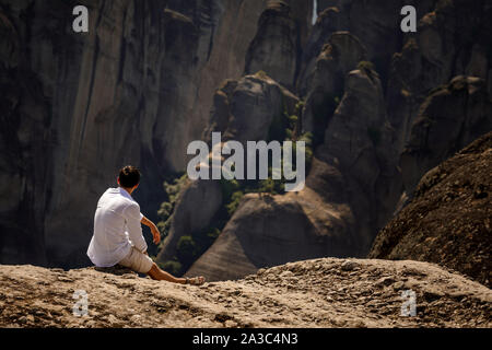 Femme touristique assis sur le sommet de la montagne sur belle scenic clif contexte près de monastères des Météores en Grèce. Banque D'Images
