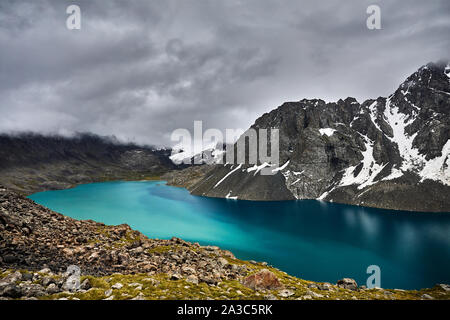 Vue aérienne de la turquoise Ala-Kul Lake dans les montagnes Tien Shan avec nuages brouillard blanc à Karakol parc national, le Kirghizistan Banque D'Images