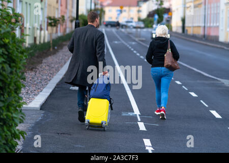 Couple en train de marcher à l'écart dans une rue urbaine déserte avec assurance dans un concept de voyage et vacances dans une vue de recul Banque D'Images