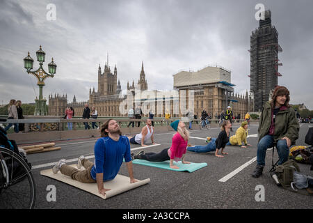 Rébellion d'extinction des séances de yoga le matin sur un territoire occupé le pont de Westminster. Les défenseurs de la commencer deux semaines de nouvelle vague de protestation action causant des perturbations dans les principaux sites à Londres comme Westminster Bridge, pont de Lambeth, Trafalgar Square, le Parlement et Smithfield Market ainsi que plusieurs blocages de routes. La Police métropolitaine ont confirmé plus de 1500 arrestations à ce jour. Londres, Royaume-Uni. Banque D'Images