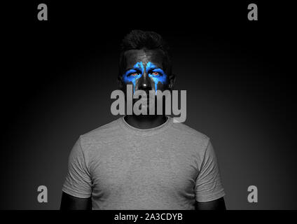 Découvrez ce qui est à l'intérieur de vous. Close up portrait of young man isolé sur fond de studio noir. Néon lumineux sur le visage. Thème Halloween effrayant, regarder, octobre vacances, concept d'horreur. Banque D'Images