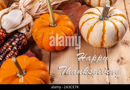 Joyeux Thanksgiving texte avec un groupe de mini potirons et le maïs sur une table en bois rustique Banque D'Images