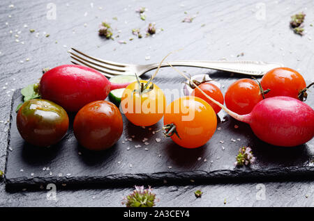 Les légumes frais biologiques sur ardoise plateau avec épices de côté libre photo concept sombre Banque D'Images