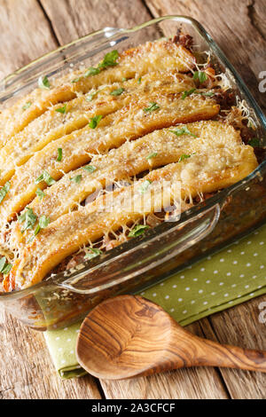 Lasagne banane pastelon avec du boeuf haché, fromage et fruits secs close-up dans un plat allant au four, sur la table verticale. Banque D'Images