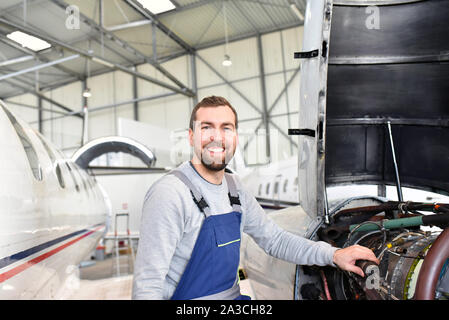 Portrait d'un mécanicien d'aéronefs dans un hangar avec des jets à l'aéroport - Contrôle de l'avion pour la sécurité et la fonction technique Banque D'Images