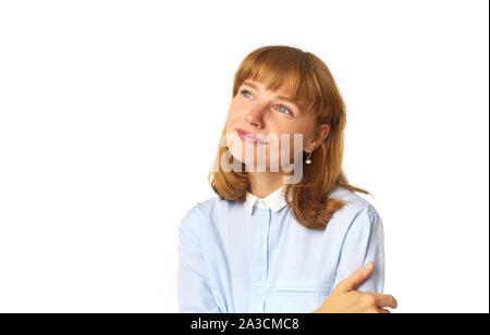 Portrait de jeune fille rousse avec des taches de rousseur et bang hairstyle habillés en chemise bleue et regardant vers le haut comme si rêver de quelque chose d'agréable Banque D'Images