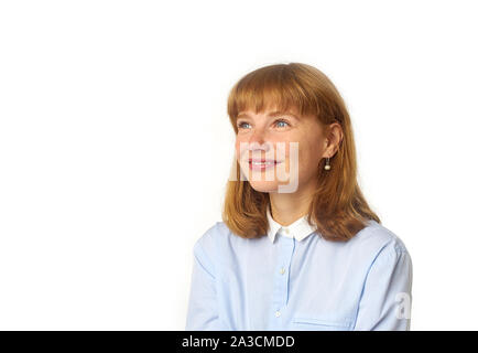 Portrait de jeune fille rousse avec des taches de rousseur et bang hairstyle habillés en chemise bleue et regardant vers le haut comme si rêver de quelque chose d'agréable Banque D'Images