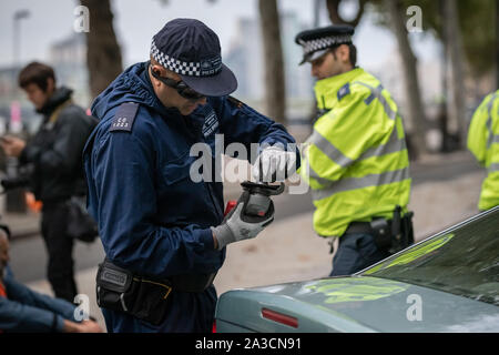 Unité de police spécialisés tentent de s'affranchir d'un manifestant sur de l'intérieur d'une voiture garée à entraver Victoria Embankment qui l'extinction des manifestants ont tenté d'occuper la rébellion à partir de 6h. Les défenseurs de la commencer une nouvelle vague de protestation a entraîné un bouleversement ce matin à Londres. Forces armées à travers l'Angleterre ont été invités à contribuer "spécialiste" des équipes de dépose de protestation formés et équipés pour faire face aux manifestants à l'aide de verrous et de la colle pour entraver les efforts visant leur élimination, car ils tentent de bloquer les principales routes. Banque D'Images